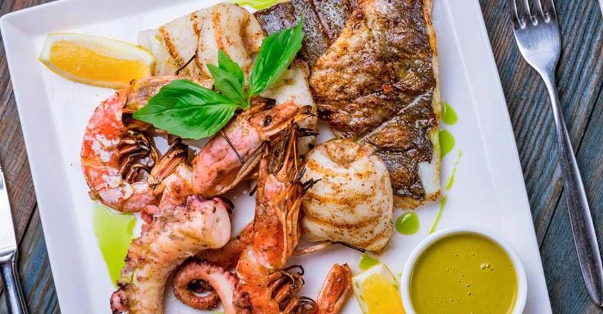 Foto referencial de parrillada de pescados y mariscos